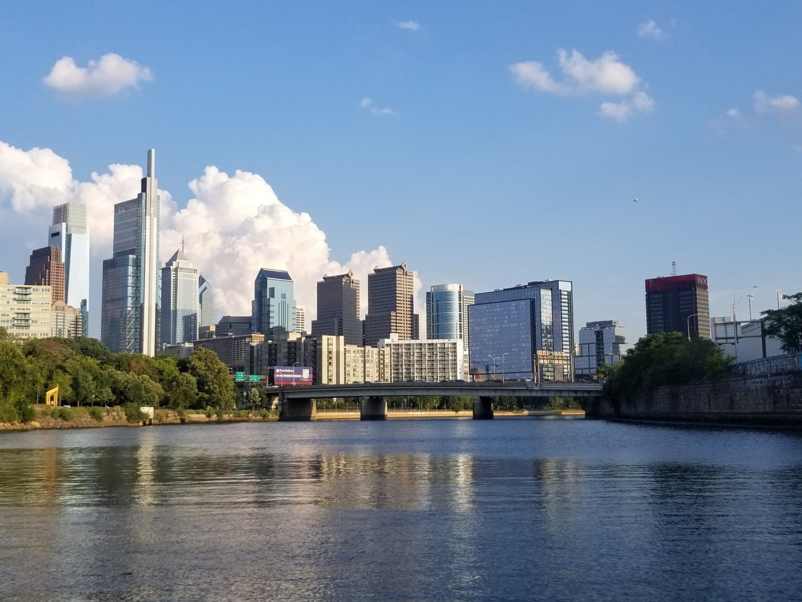 a bridge over a body of water with a city in the background
