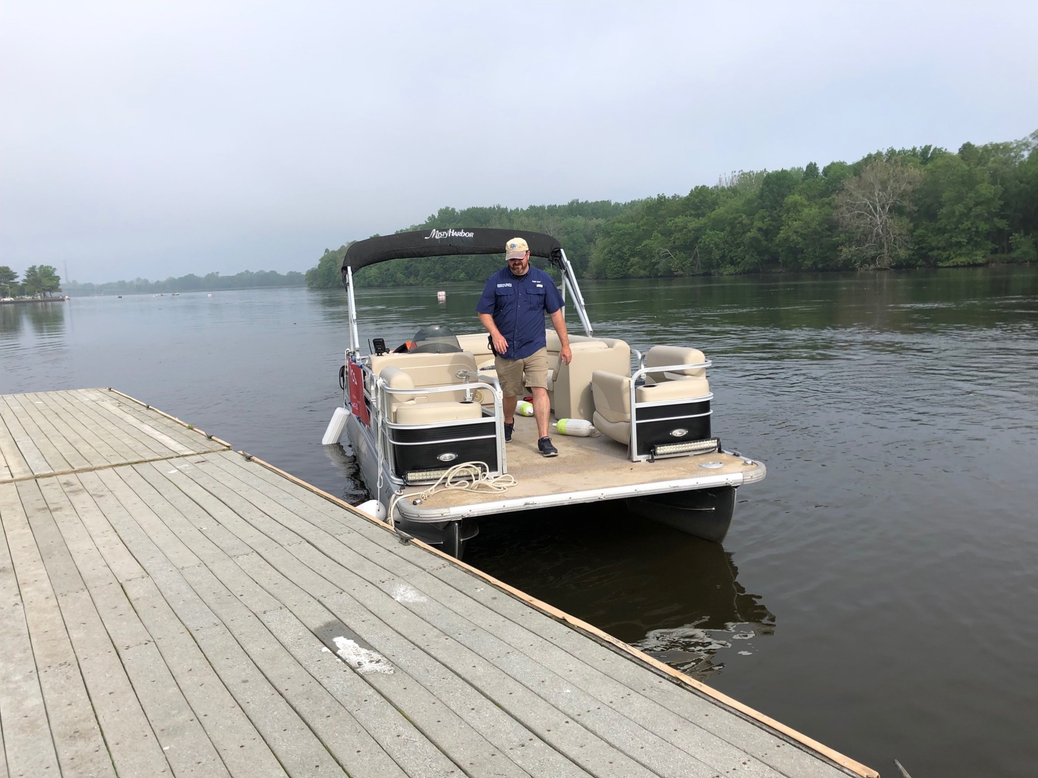 a man sitting on a dock next to a body of water
